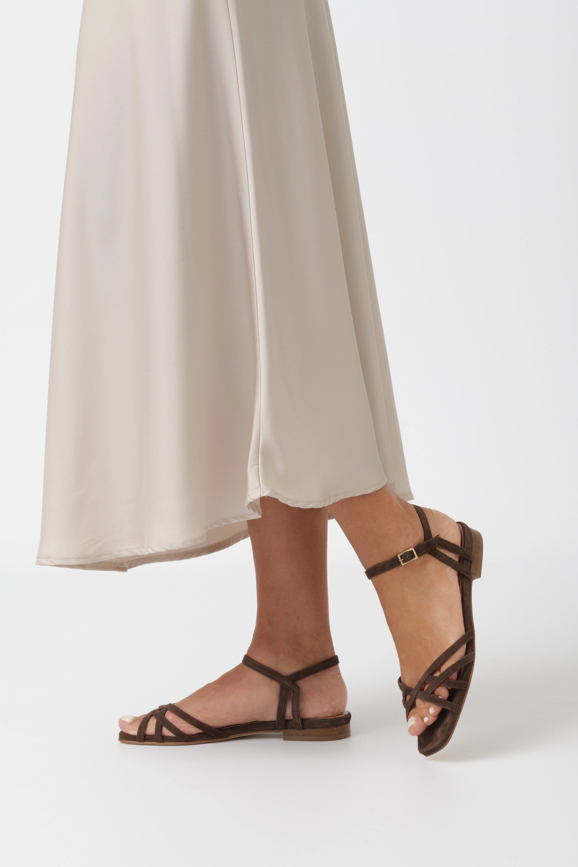 Dark brown suede flat sandal with criss-cross straps and a low ankle strap