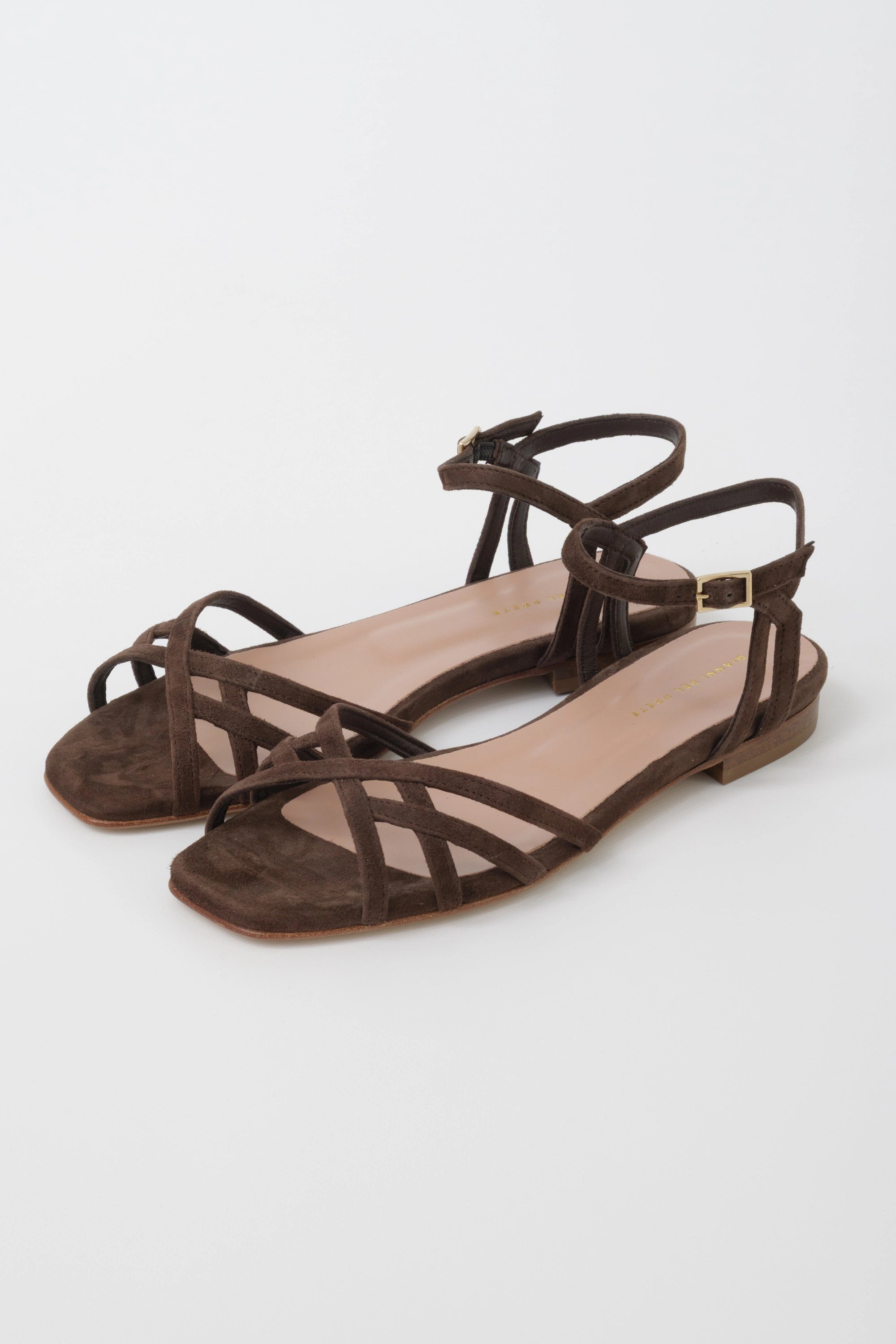 Dark brown suede flat sandal with criss-cross straps and a low ankle strap